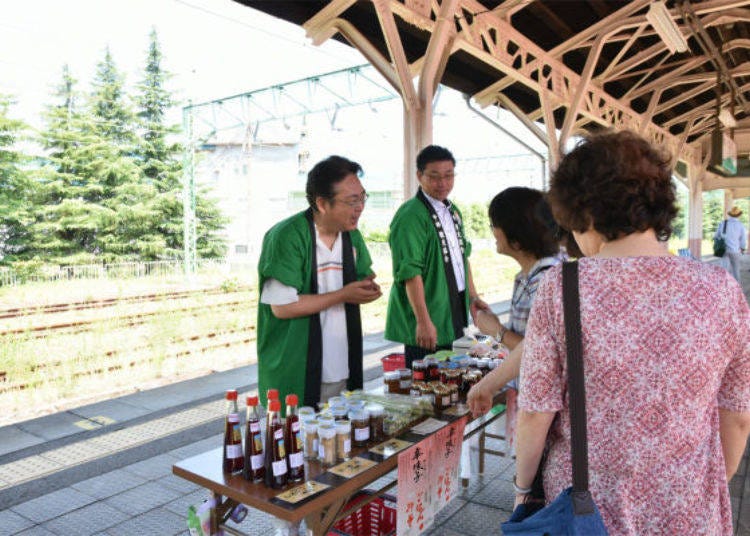 ▲ Members of the local Joetsu City Nakago-ku Hospitality Group welcomed us on the platform with an array of fresh vegetables and local specialties.