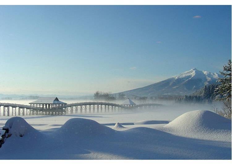 ▲Tsuru-No-Mai Bridge in winter. Tsugaru-Fuji, or Iwaki-san mountain, is in the background