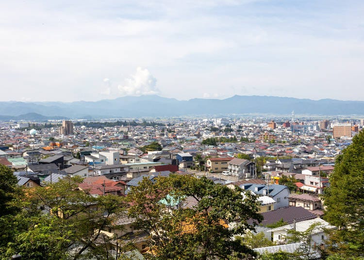 The boys observed the destruction of their town from this vantage point on Mt. Iimoriyama. Tsurugajo Castle is on the left, far behind the row of trees in the distance. (Photo: PIXTA)