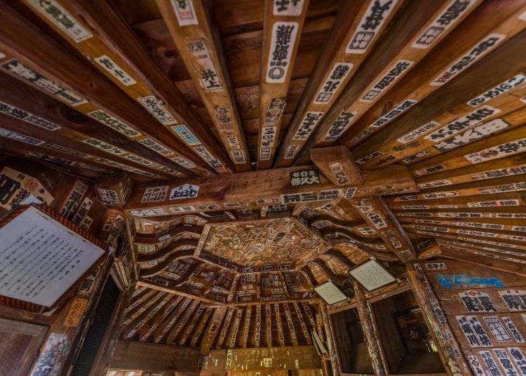 牆壁和天花板上貼滿了千社札，是幾個世紀以來無數朝聖者訪問榮螺堂的證明。（圖片來源：Aizuwakamatsu Tourism Bureau）