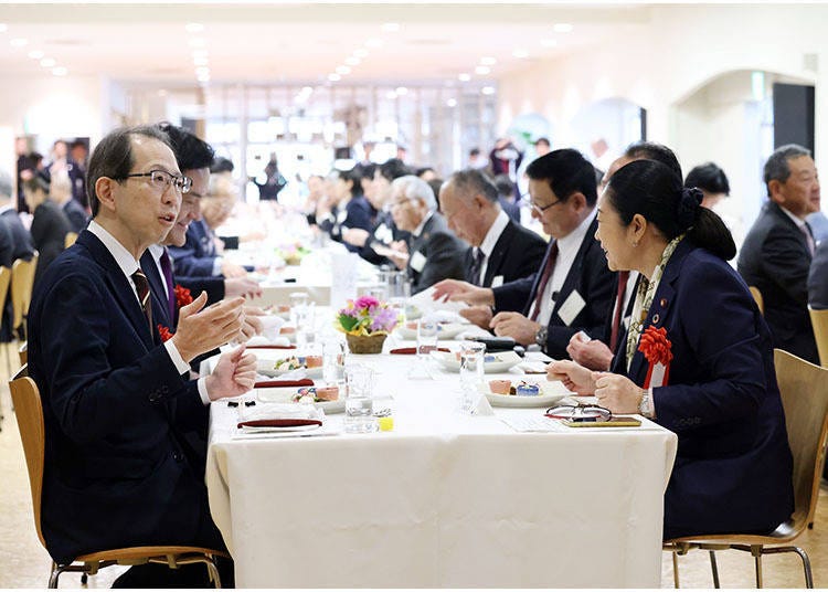 About 100 people, including Masao Uchibori, the governor of Fukushima Prefecture (left foreground), and Shinako Tsuchiya, Minister for Reconstruction (right foreground), tasted these dishes brimming with the charms of Fukushima Prefecture.