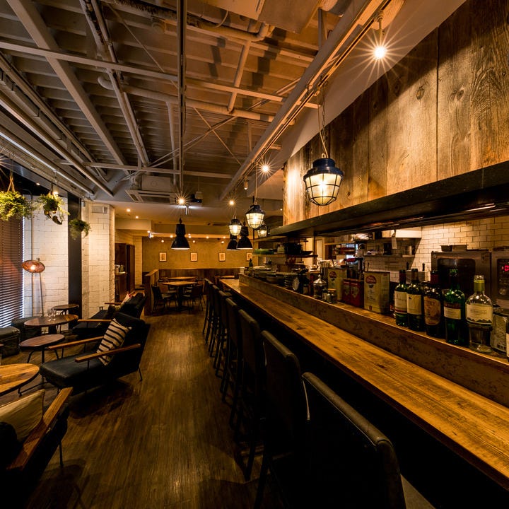 淡い電球の灯りとブラウンで統一されたウッディーな内装がおしゃれなイタリアンキッチン バンサン 金町店の店内