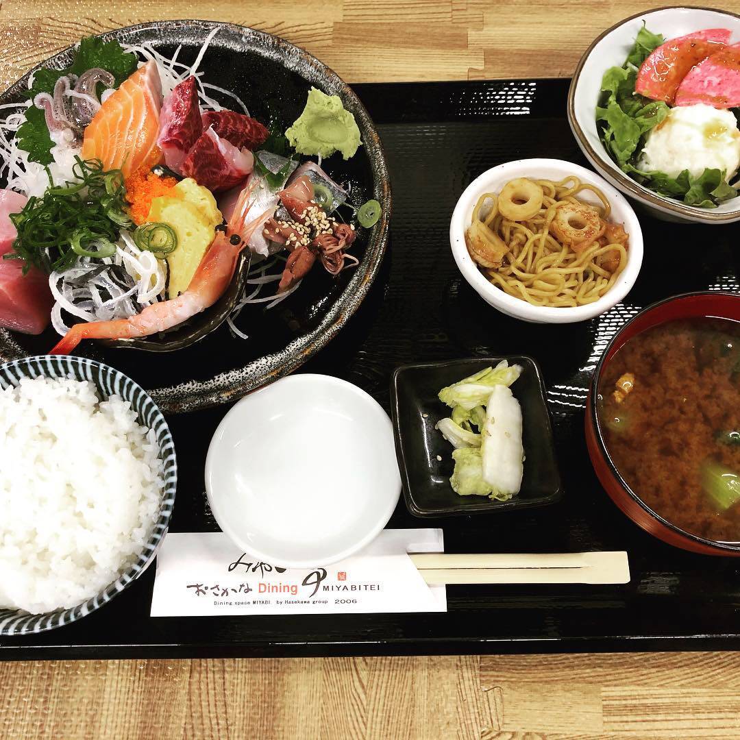 たくさんの小鉢に囲まれ、黒のトレーにのった刺身定食