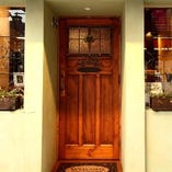 若草色の外壁とステンドグラスのアンティーク調ドアが目印。
