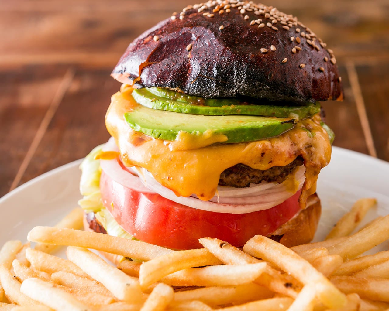 こんがり焼けたバンズにお肉、アボカド、チーズ、付け合わせにフライドポテトが付く