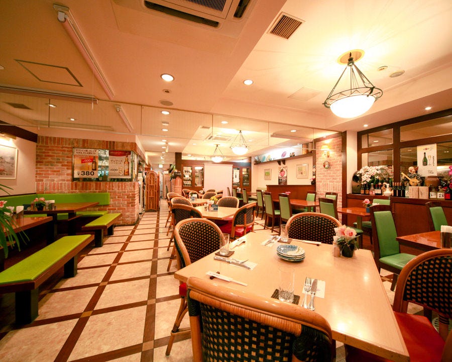 緑の椅子とベージュのテーブルが並んだレトロな店内