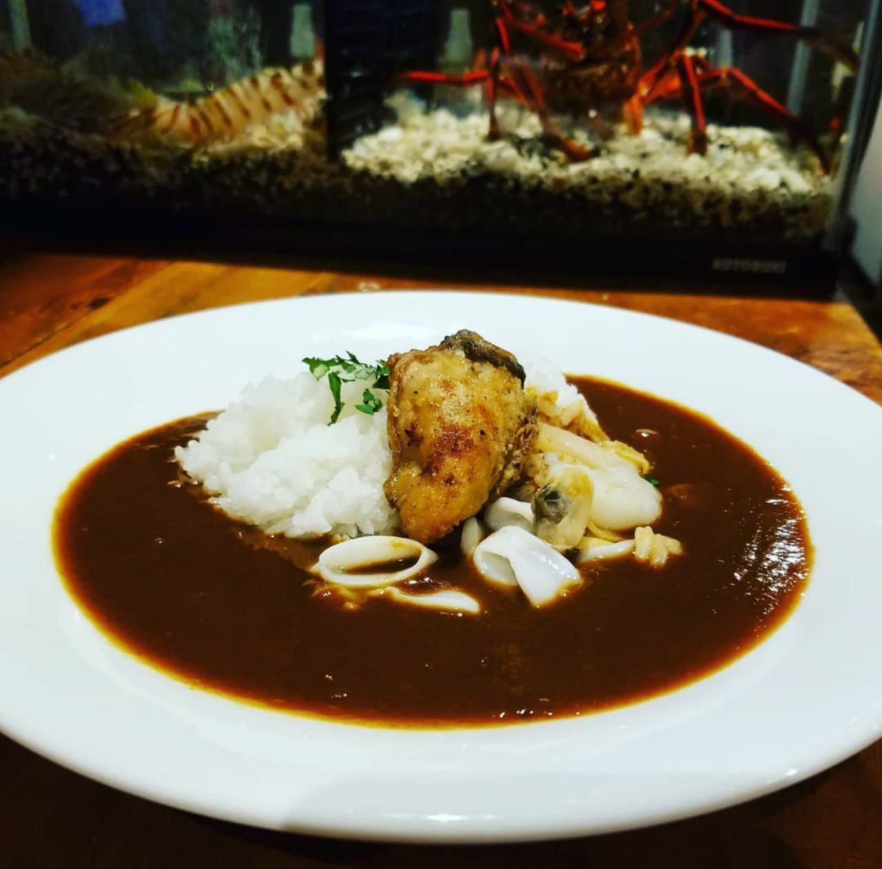 白く丸い皿で提供されるオイスターバーのシーフードカレー
