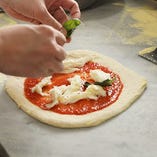 当店のピザはナポリ風の"もちもち"とローマ風の"サックリ"を併せ持つオリジナルスタイル！イタリア産と国産の小麦粉をブレンドした特製の生地をお楽しみください。
