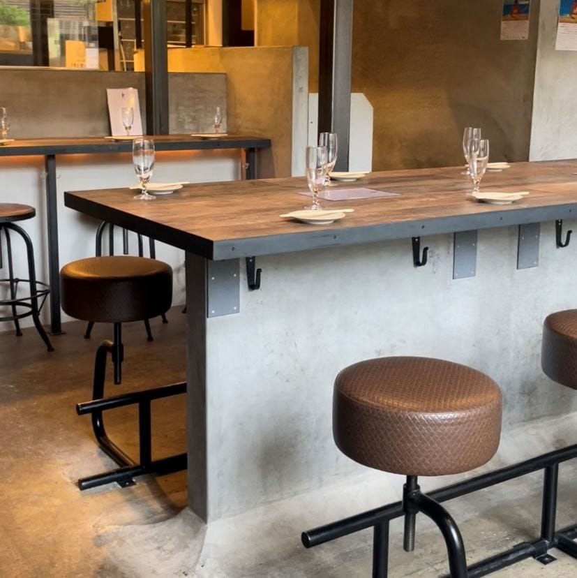 打ちっぱなしのカウンターテーブルと茶色の丸椅子