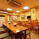 【1階席：お蕎麦屋】～24名様用テーブル席…昭和の雰囲気を漂わせる店内で変わらぬ伝統の味、利久庵のお蕎麦をお楽しみいただけます。席と席の距離も広く、隣を気にせず気軽にご利用いただけるお席となっています。