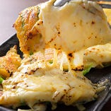 女性に大人気！『チーズチヂミ』はとろ～り溶けたチーズがこってり乗ったチヂミ。キムチを巻いて食べるとほんのりの辛味と食感がアクセントに！