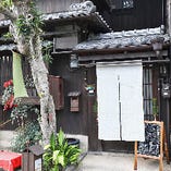 狭い間口の京町家ならではの佇まい。白い暖簾が目印です。