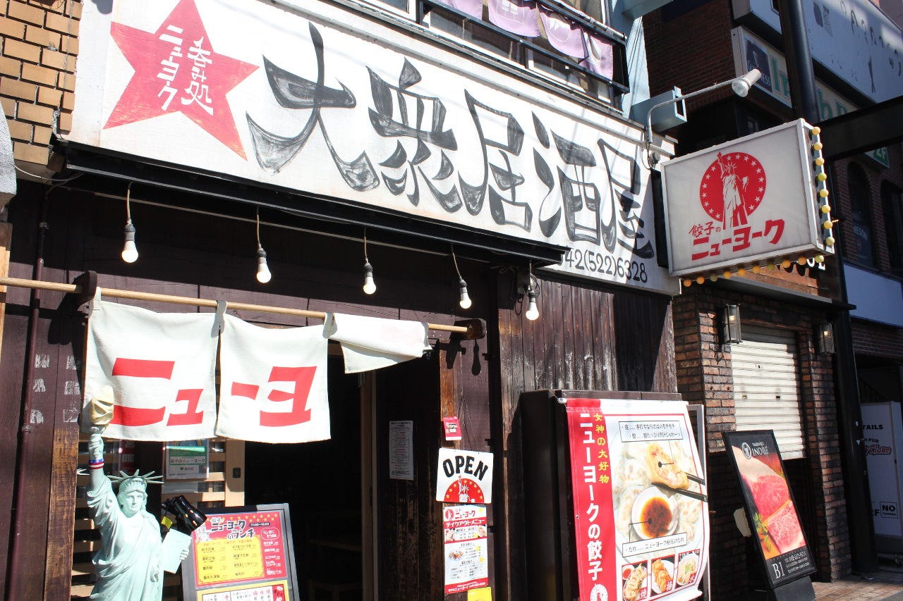 大きな手描き風の看板が目を惹く餃子のニューヨーク 立川店の店舗外観の様子