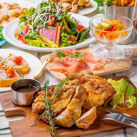 ローズマリーチキンやサラダ、生ハムが並んだテーブル