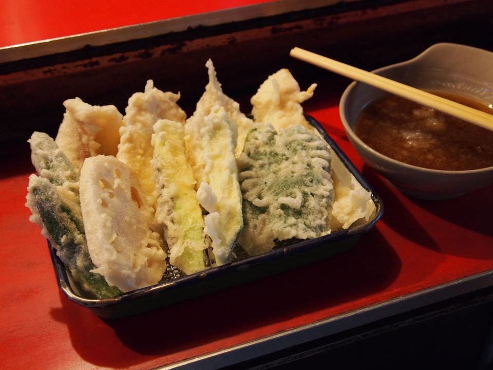 トレイに盛られた野菜や魚、肉の天ぷらと天つゆが入った器