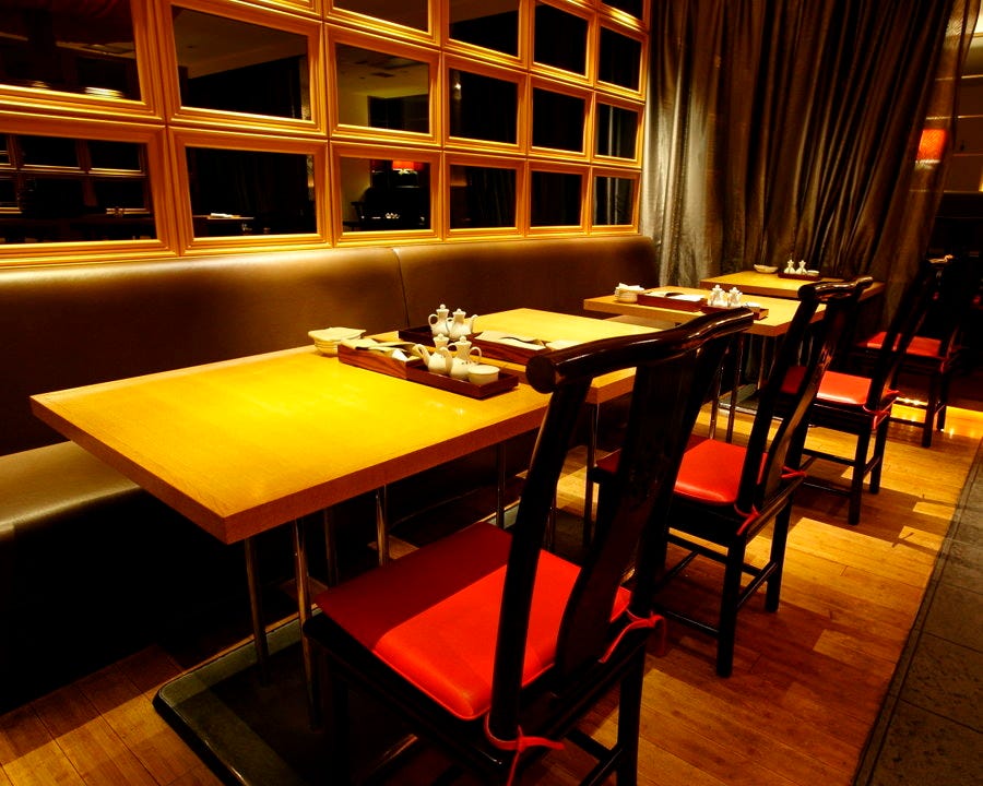 横並びになった木のテーブルと赤いチェア