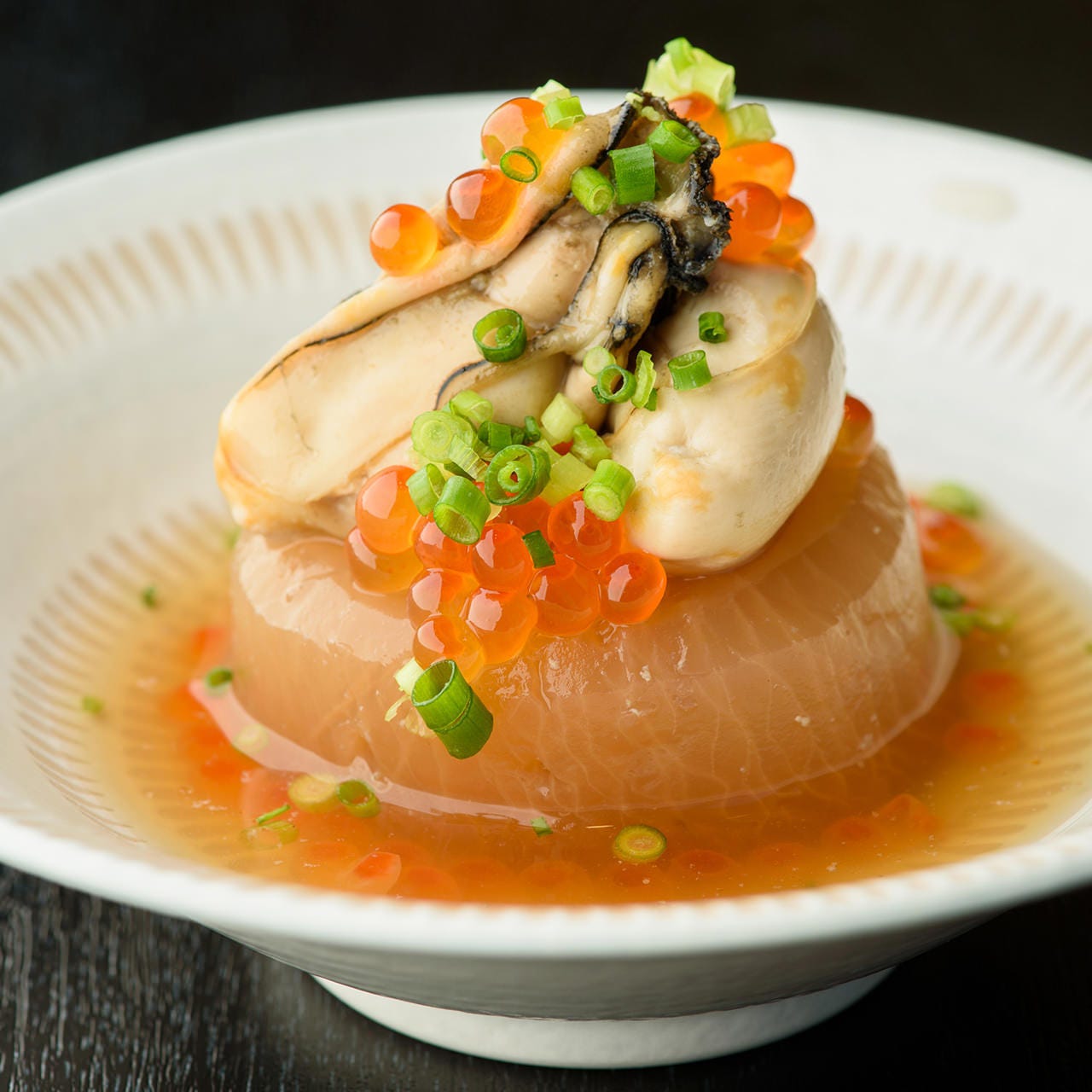 白い皿の上に「広島県産牡蠣大根（イクラ金箔）」が盛られている