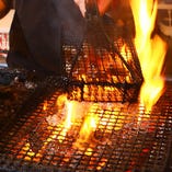 豪快な火柱を上げて焼き上げる、さつま知覧鶏もも肉の炙り焼は、迫力満点！