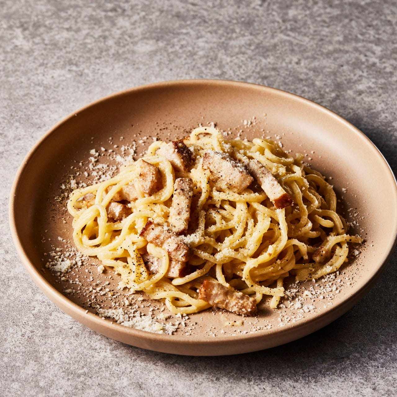 ブラウンの器に盛られたカルボナーラパスタ
