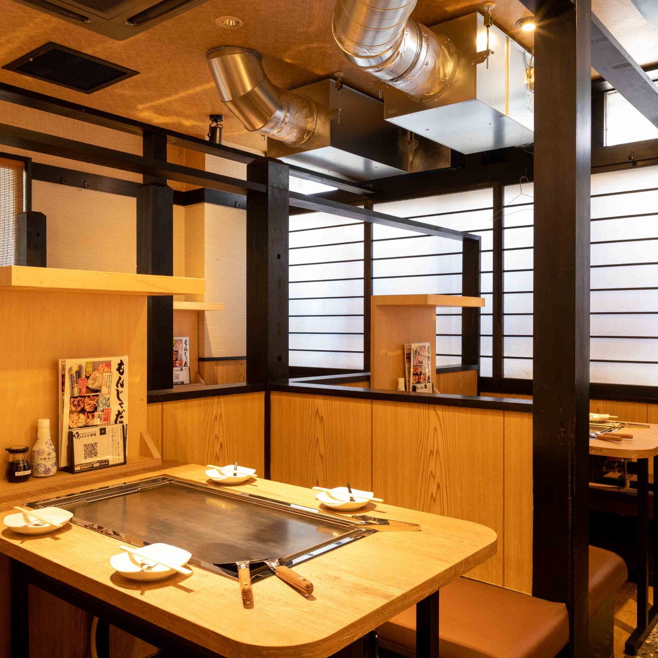 鉄板が設置されたもんじゃ酒場だしや 難波店のテーブル席