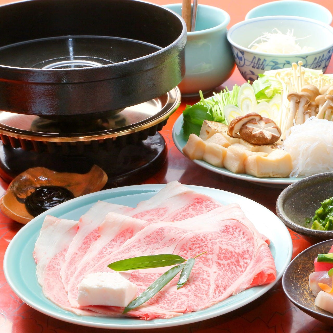 テーブルの上に江戸菊の「すき焼きコース-A5ランクの国産黒毛和牛霜降り肉と新鮮海鮮を食す-」が置かれている