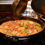 京都産の万願寺とうがらしや、九条葱を使用！風味豊かなエシャロットも使い、オリジナルの豆板醤で作るアッツアツ麻婆豆腐も人気の逸品！豆板醤をしっかりと熟成させ、自然でガツンとくる辛さです。中華鍋で豪快に煮込み、専用の鉄板鍋で、熱々のままお持ちいたします。見た目も豪快なので、最近ご注文される方が続出です！