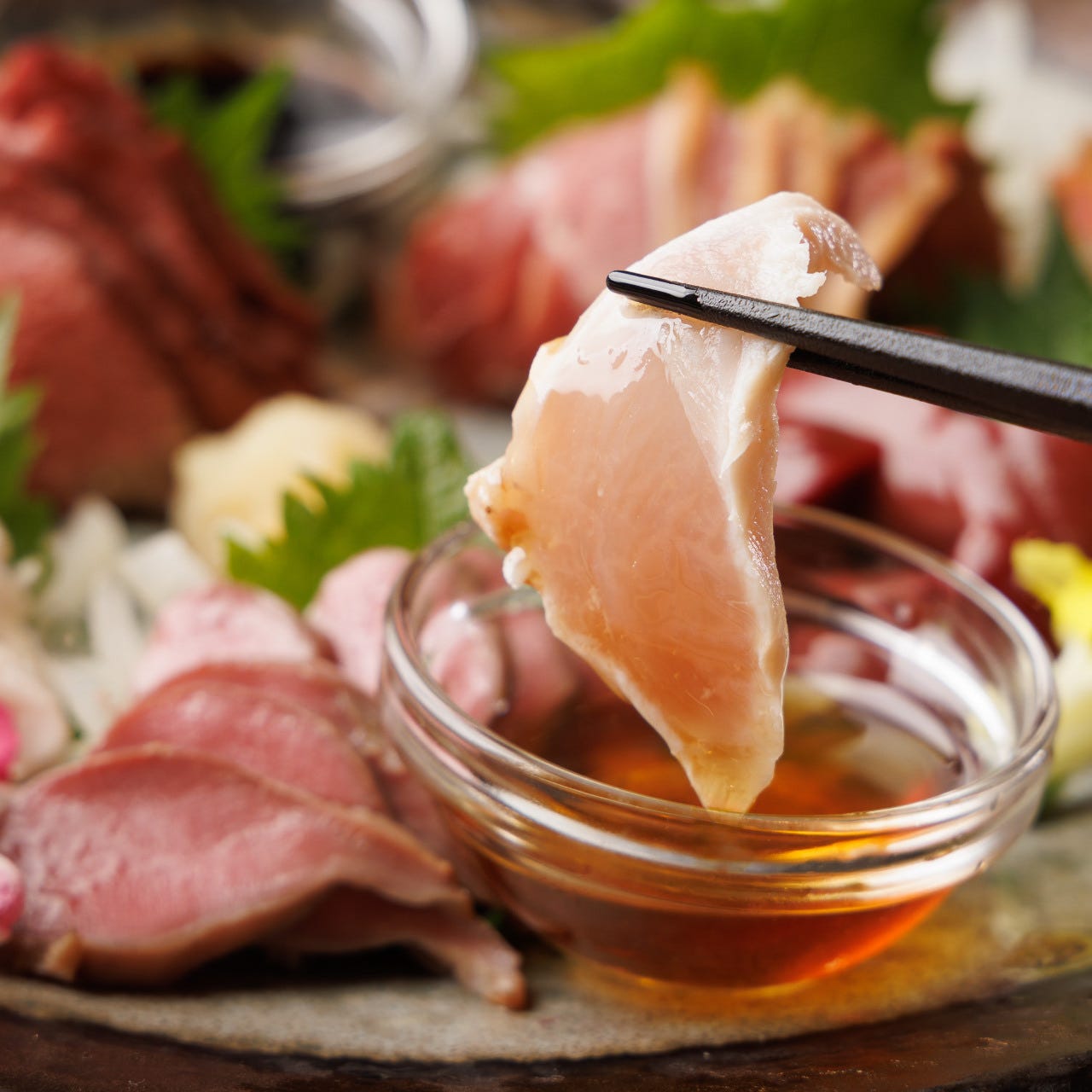 とりせん 立川本店の刺身を箸で持っている様子