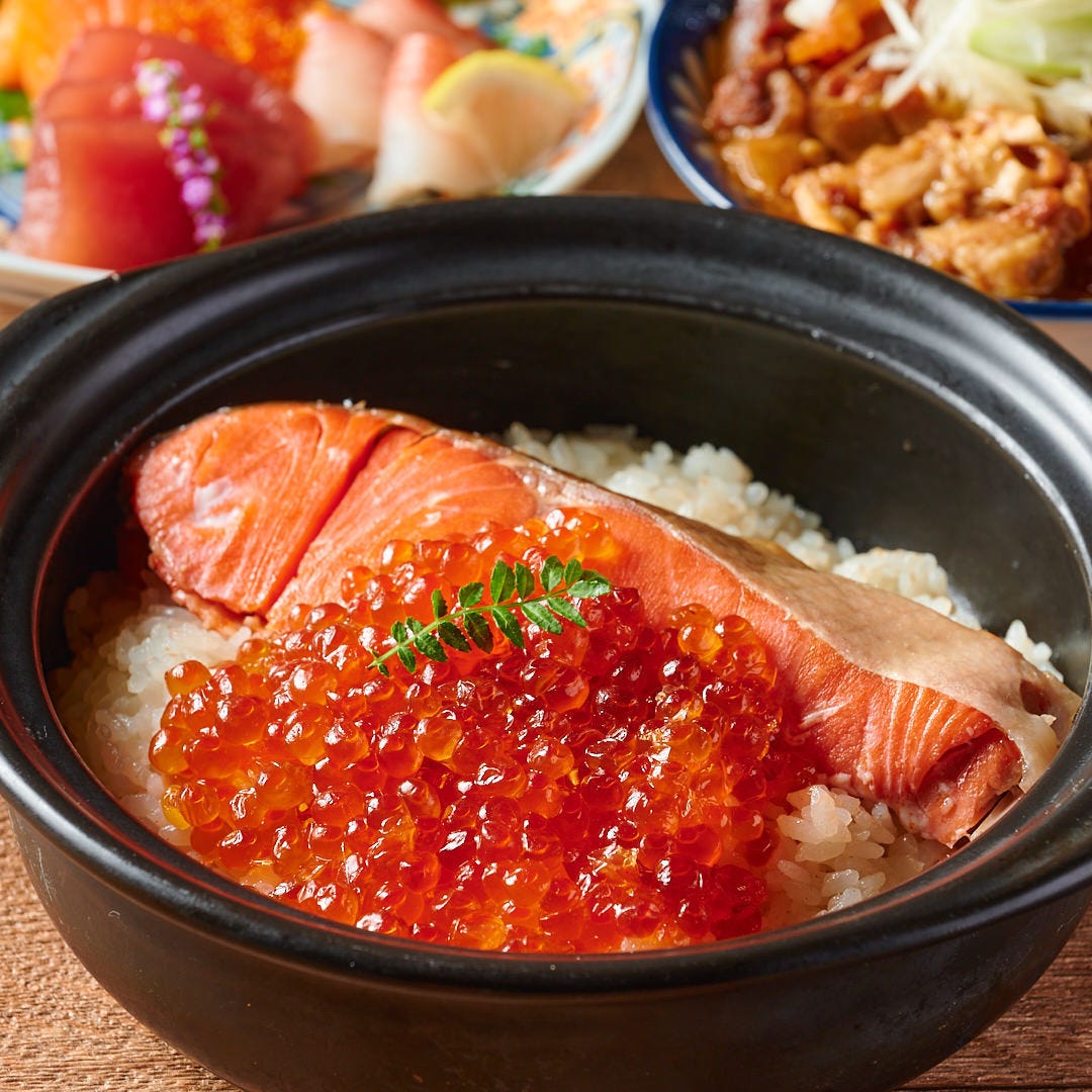 鮭といくらの土鍋ご飯がブラウンのテーブルにならんだ様子