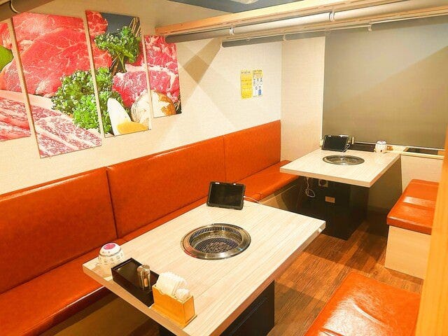 赤い椅子と木のテーブルが並んだ個室韓国焼肉 萬和苑 池袋店の店内