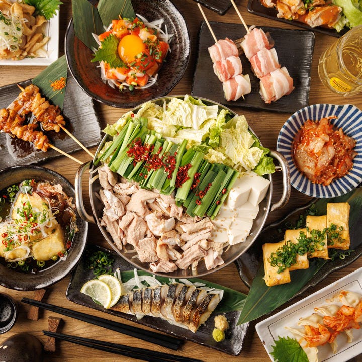 もつ鍋や焼き鳥などバリエーション豊富な料理がテーブルに並んでいる様子