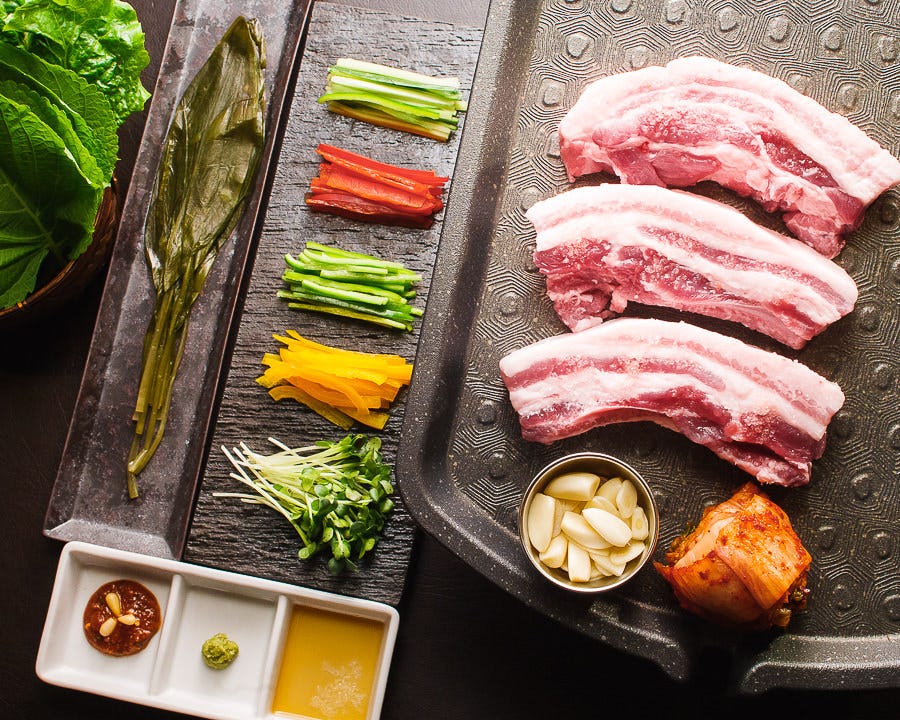 お肉や薬味が綺麗に盛り付けられた生サムギョプサルコース