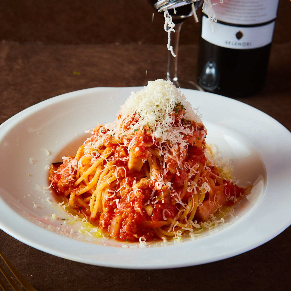 ラグーミートソースにチーズをかける様子