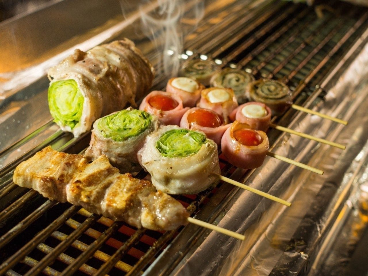 焼き網で焼かれている野菜串