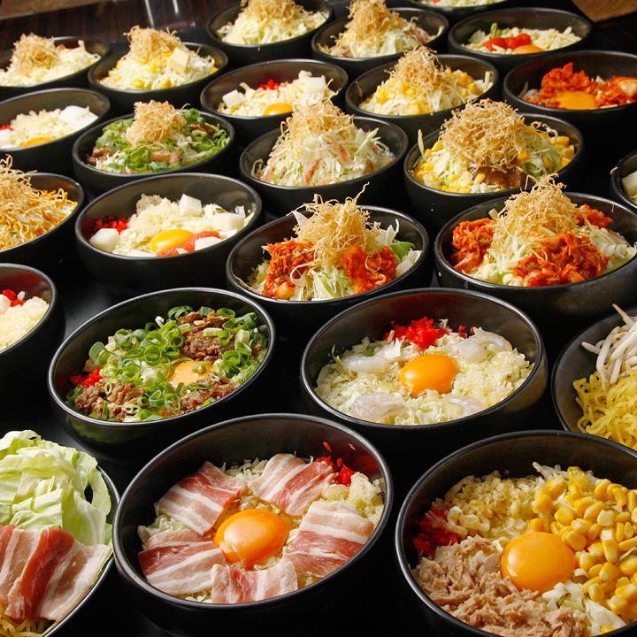 お好み焼きの材料が並んだボウル。キャベツ、卵、ネギ、豚肉、コーンなどが入っている。