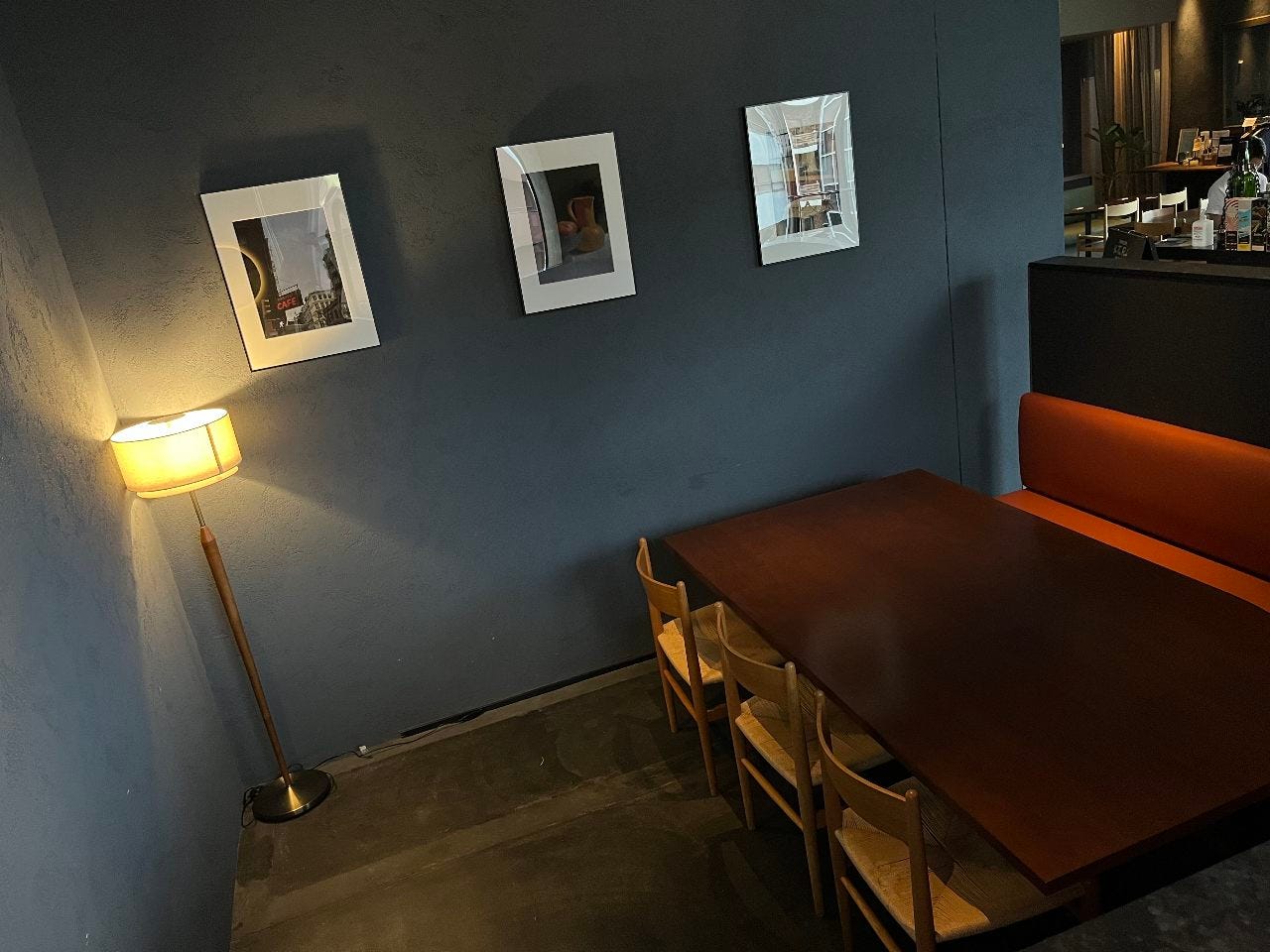 シックな青色の壁に間接照明がおしゃれな半個室の席