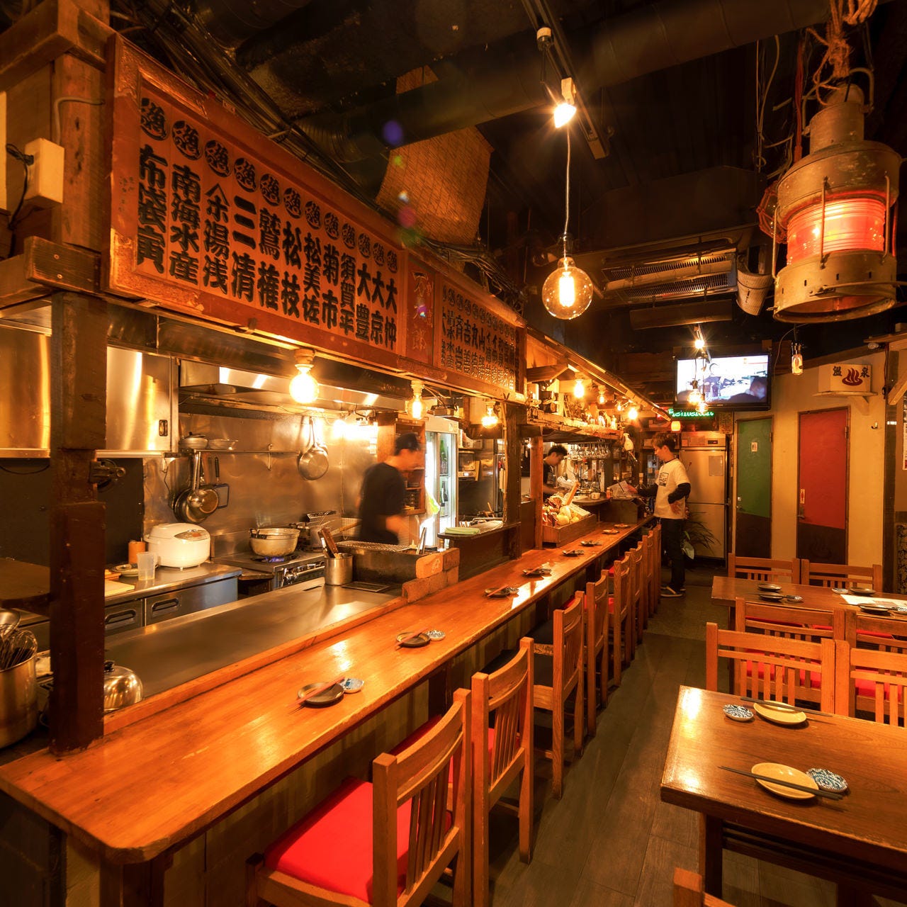 カウンター席から厨房が望める立川酒場魚丸 南口店の店内