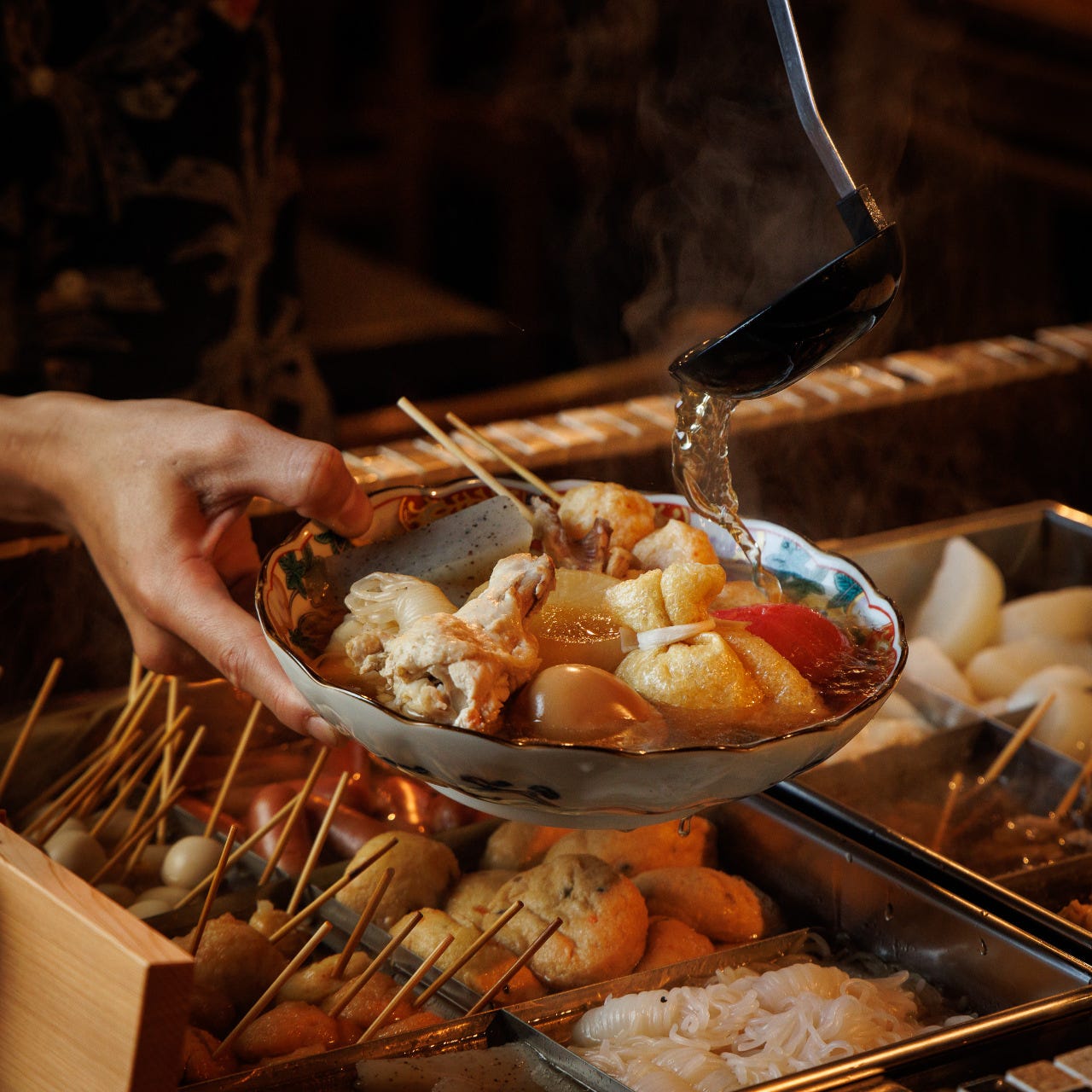 立川酒場魚丸 南口店のおでんを皿に盛り付けている様子