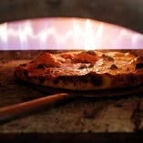 500℃の専用窯で焼き上げる当店名物「窯焼きピザ」。高温の火力で一気に焼き上げる時間は90秒。この火力と時間が、外はカリッ＆中はしっとりもちもちのおいしさの秘密です。