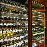 壁一面のワイナリーには、世界各国から取り寄せた様々なワインを保管しております