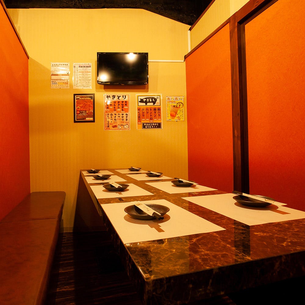 暖色の壁とシックなテーブルで落ち着いた雰囲気の個室