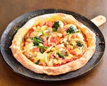 注文を受けてから焼き上げるピザは野菜たっぷりの薄焼きタイプ。