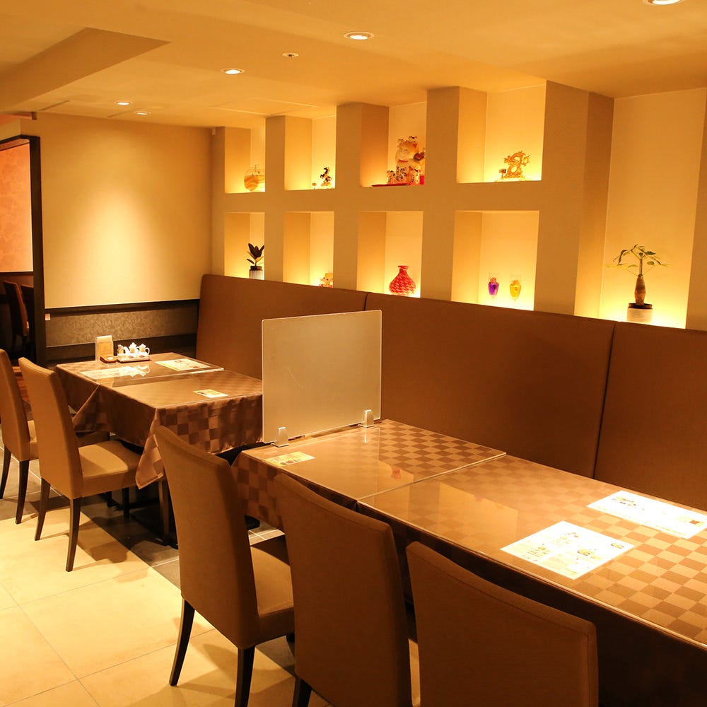 あたたかみのあるオレンジの照明が印象的な店内に並ぶテーブルと椅子