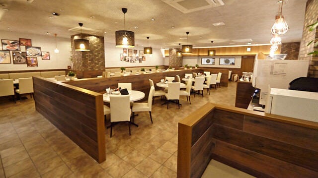 白いテーブルと椅子が並ぶ餃子総本店 上大岡店の店内