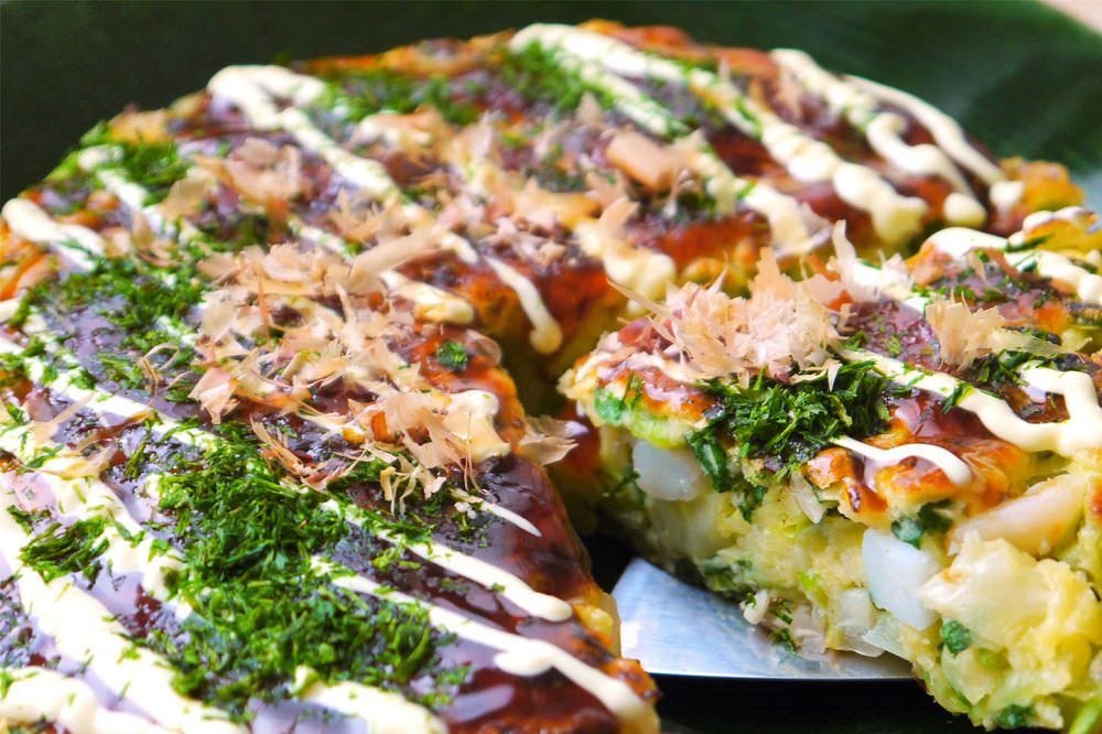 豚玉のお好み焼きを4分の1にカットしている様子