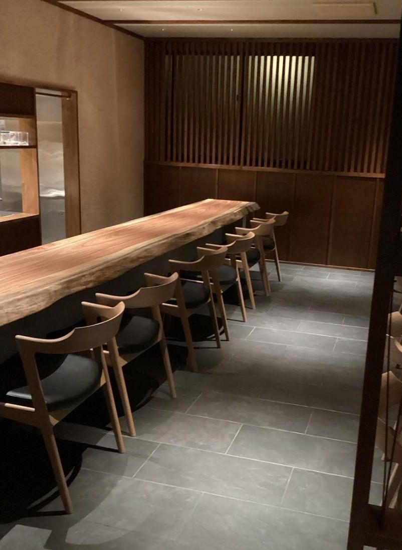 リョウリヤ カワサキの木製カウンター席といすが並んでいる