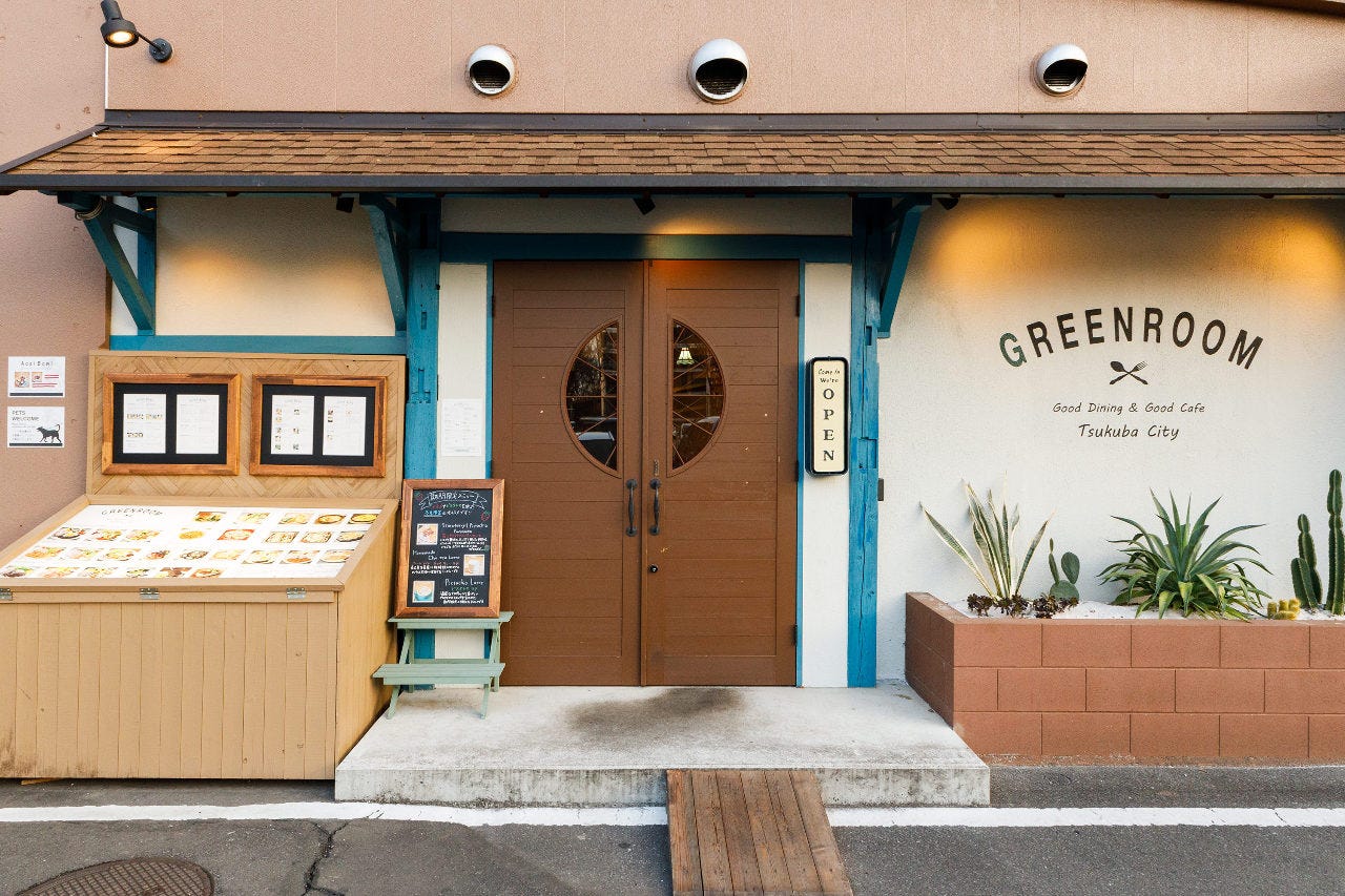 白と青の壁とブラウンの扉が印象的な入り口