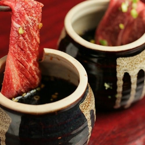 NO.1 焼肉しゃぶしゃぶ 新宿歌舞伎町店の臺つけカルビを箸上げしている様子