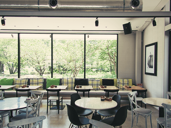 窓から公園が見える城を基調とした開放的な雰囲気の店内