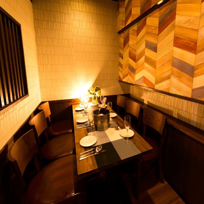 ヘリボーン調の壁とオレンジの灯りが印象的なビストロBBQ コーヒヌール 品川店の個室テーブル席