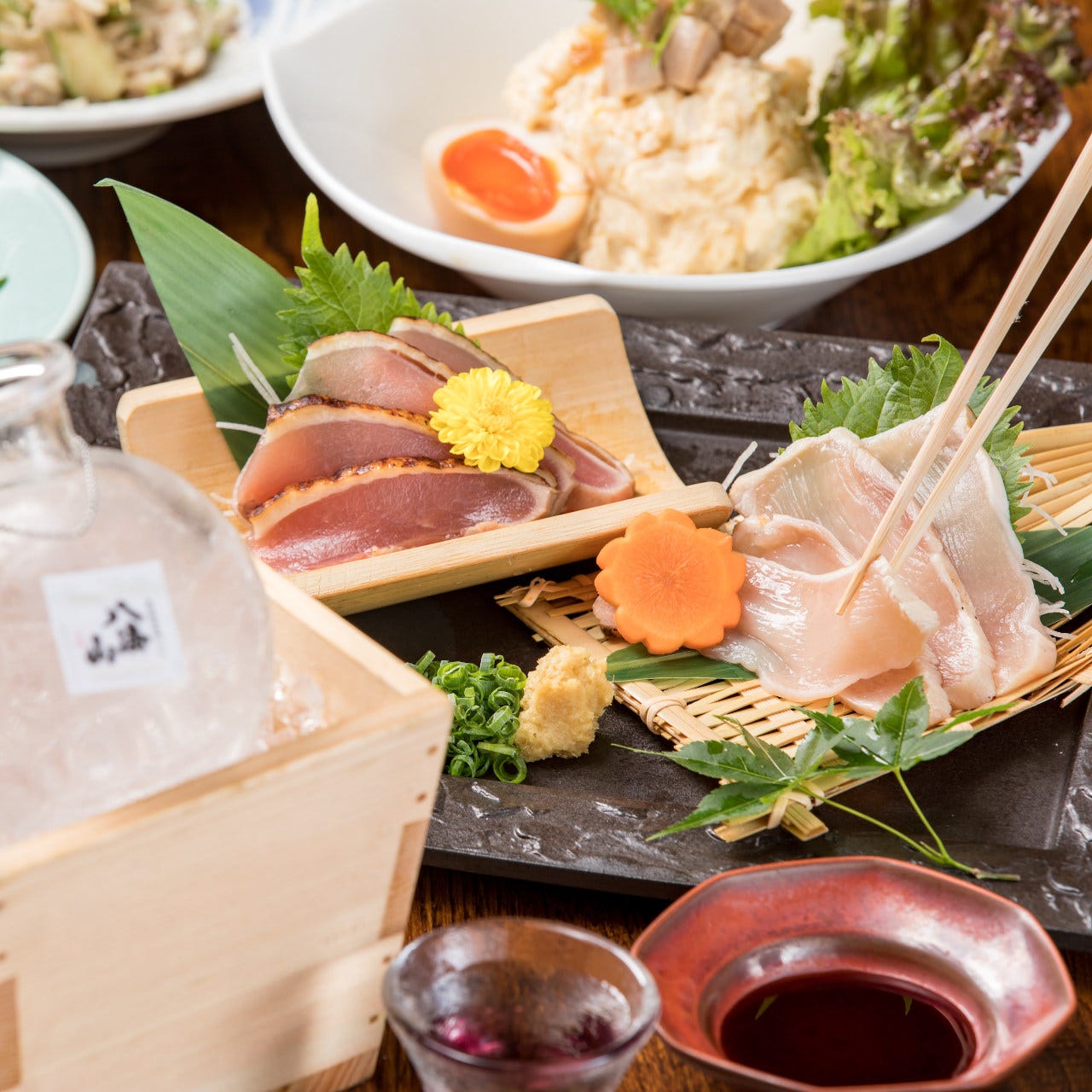 刺身や升に入ったお酒が並べられている様子